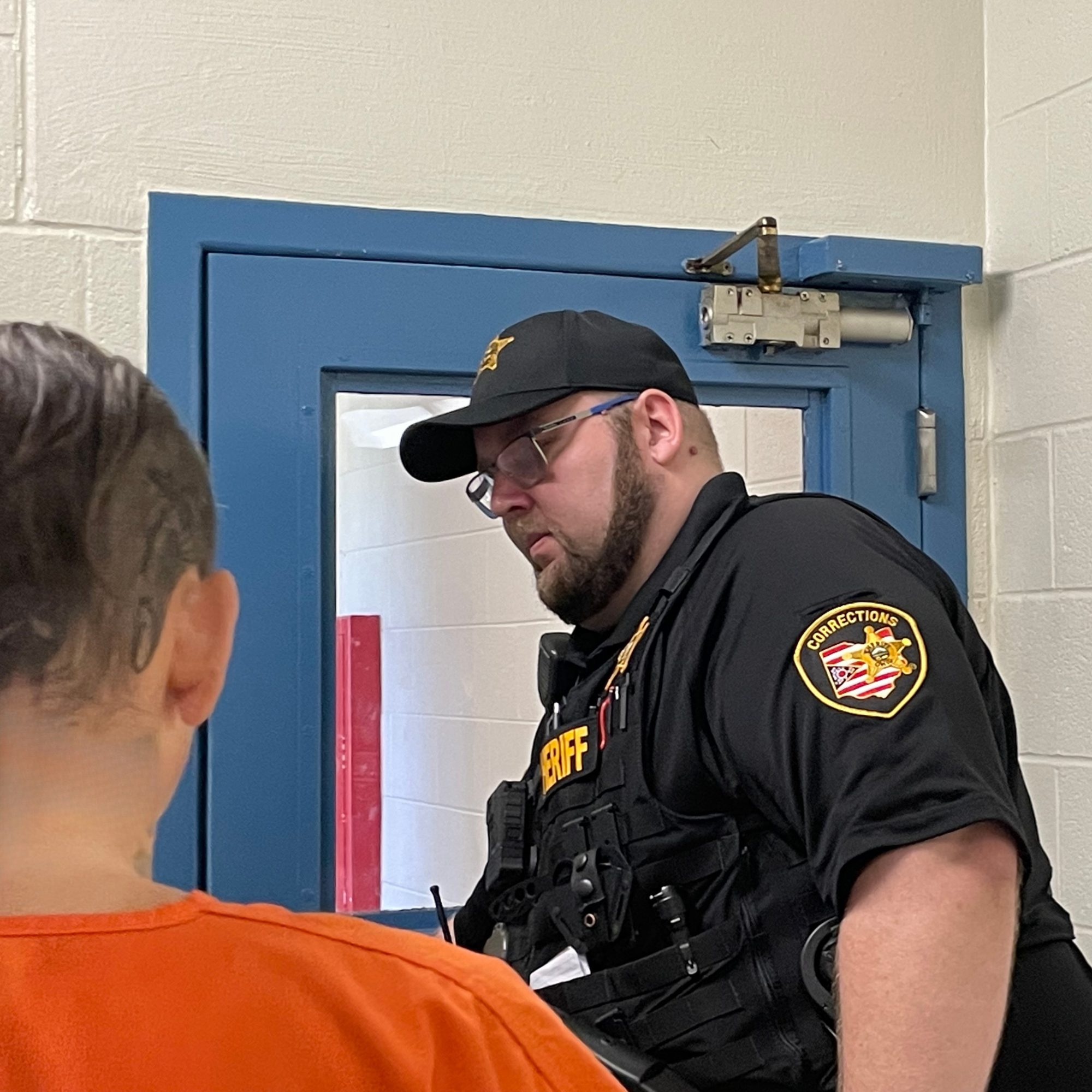 A corrections officer opening a door.